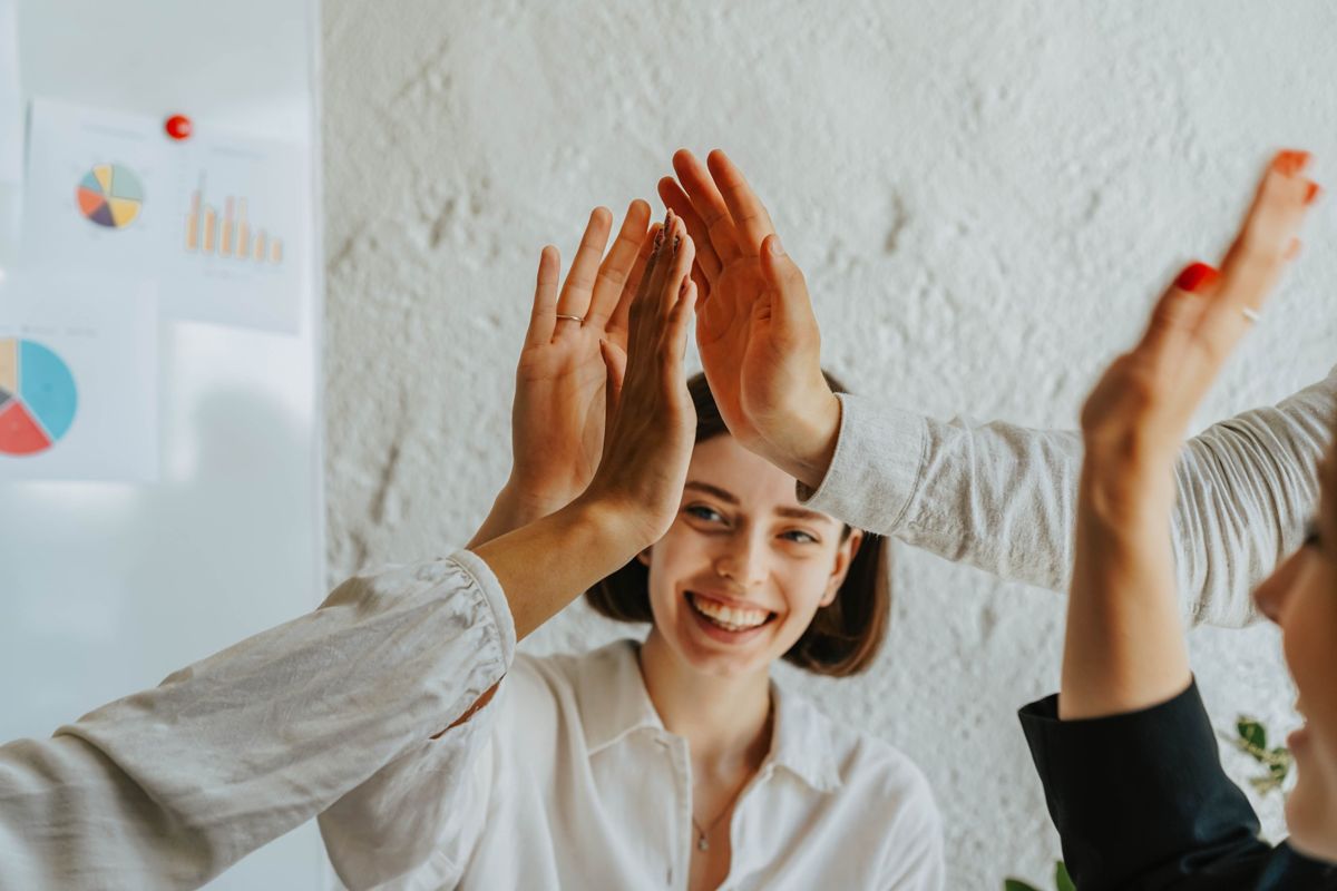 A team high-fiving together in a meeting room