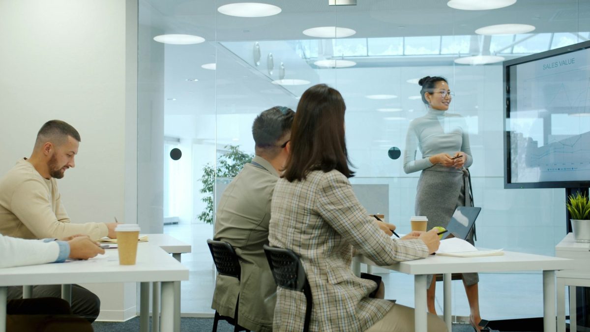 A trainer presenting to a small group seated at desks